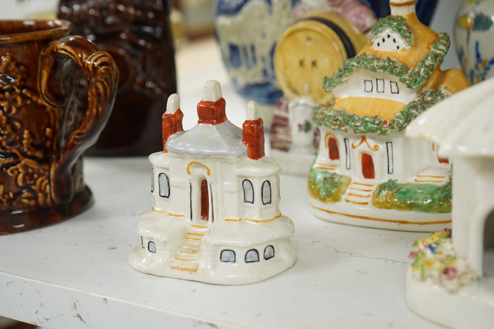 A group of various Victorian Staffordshire pottery models of cottages and various figure moulded vessels together with an Italian maiolica ewer, tallest 25cm